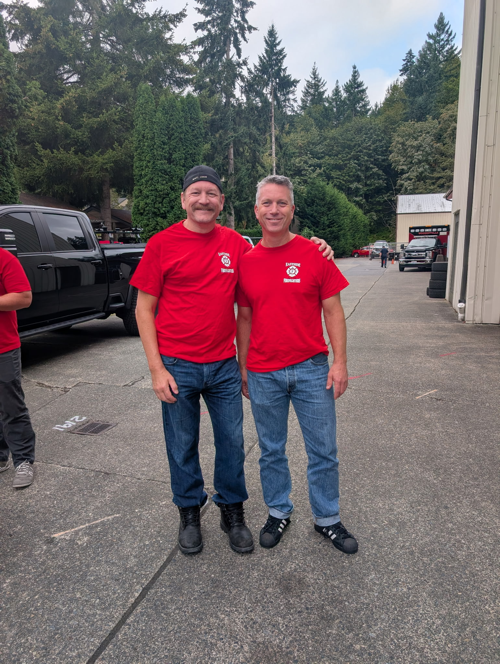 Ray Austin standing beside a man in matching red firefighter shirts